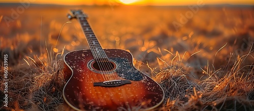 Acoustic Guitar Resting in a Field at Sunset