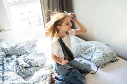 Cute Little Girl Drying Hair With A Hairdryer In Sleeping Room