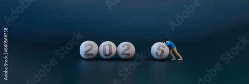 Obraz na płótnie Tiny person are pushing wooden circular lace into the new year 2025. the new year is coming w salonie