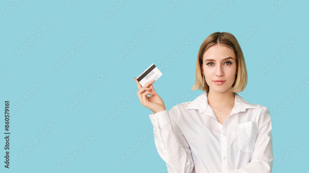 Cashless payment. Bank service. Financial operation. Stylish woman smile holding credit card isolated on blue empty space. Advertising background. Cashless payment. Bank service. Financial operation. Stylish woman smile holding credit card isolated on blue empty space. Advertising background.