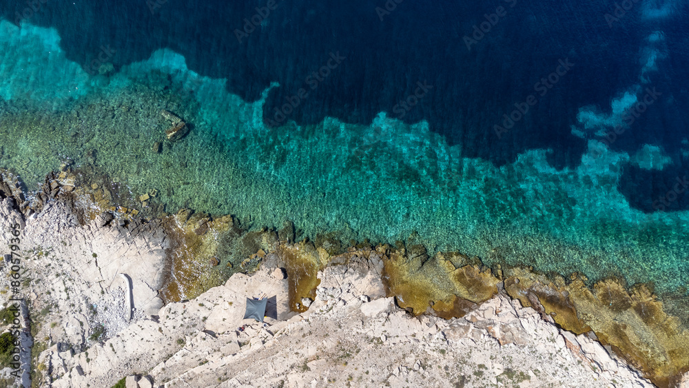 drone view of sun sail on the Mediterranean coast of the island Zirje in Croatia