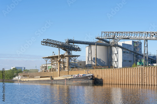 Beladen eines Schiffes mit Rapsextraktionsschrot, ein Nebenprodukt bei der Gewinnung von Rapsöl aus Rapssamen, im Hafen von Magdeburg photo