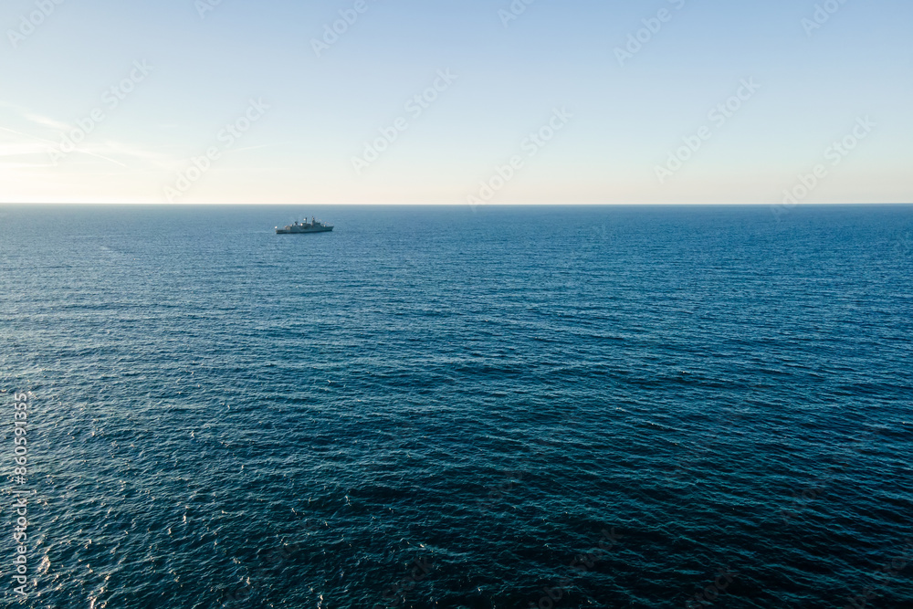 Aerial top view by drone of the sea with warship on horizon. Aerial top view by drone of the sea with warship on horizon.