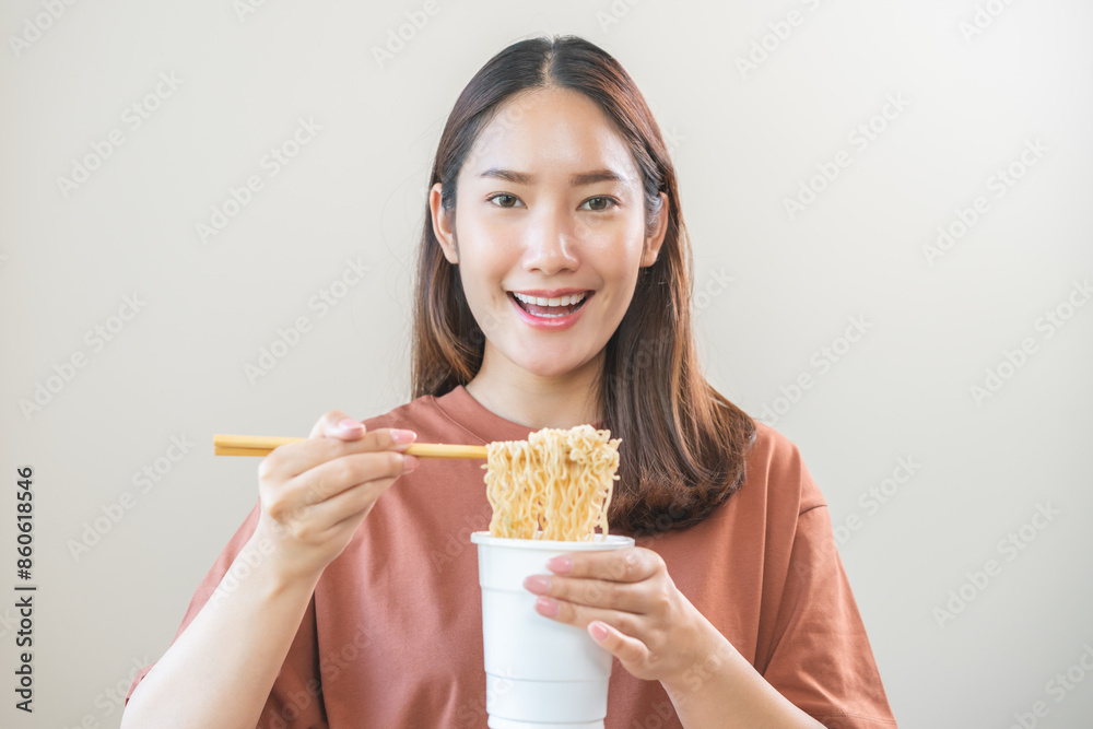 Happy temptation, attractive asian young student woman, cute girl using chopsticks eating instant ramen, noodles soup from a cup, cooking meal fast food lifestyle of traditional japanese person. Happy temptation, attractive asian young student woman, cute girl using chopsticks eating instant ramen, noodles soup from a cup, cooking meal fast food lifestyle of traditional japanese person.