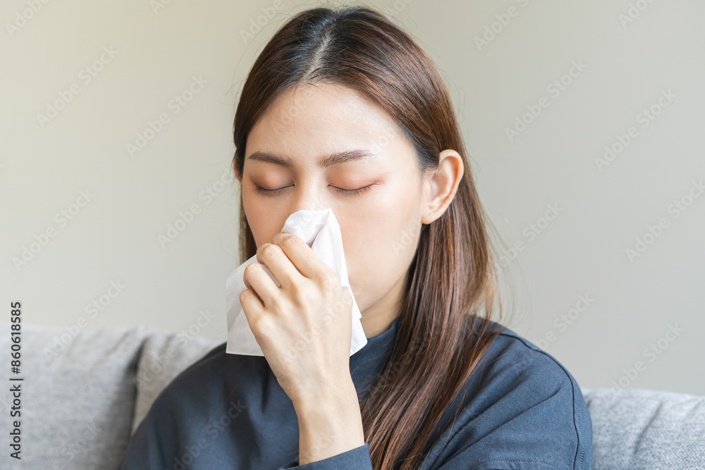 Sick, coronavirus or covid-19, attractive asian young woman, girl have a fever, flu and hand in use tissues paper sneezing nose, runny while sitting on sofa, couch at home. Health care on virus person Sick, coronavirus or covid-19, attractive asian young woman, girl have a fever, flu and hand in use tissues paper sneezing nose, runny while sitting on sofa, couch at home. Health care on virus person