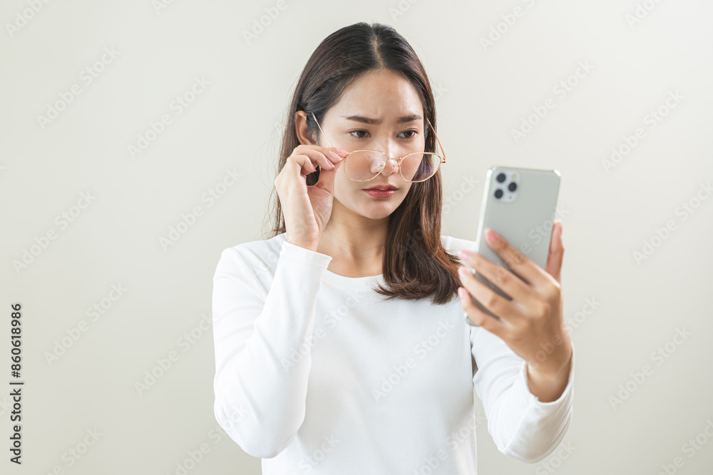 Presbyopia, Hyperopia middle aged asian woman holding eyeglasses problem with vision blurred ,trying to read text message from smart mobile phone screen, eye disease of old, eyesight farsightedness. Presbyopia, Hyperopia middle aged asian woman holding eyeglasses problem with vision blurred ,trying to read text message from smart mobile phone screen, eye disease of old, eyesight farsightedness.
