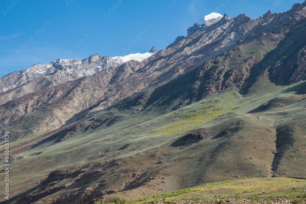 Fototapeta premium A dirt road through a field with mountains in the background, Zanskar, Himalayas