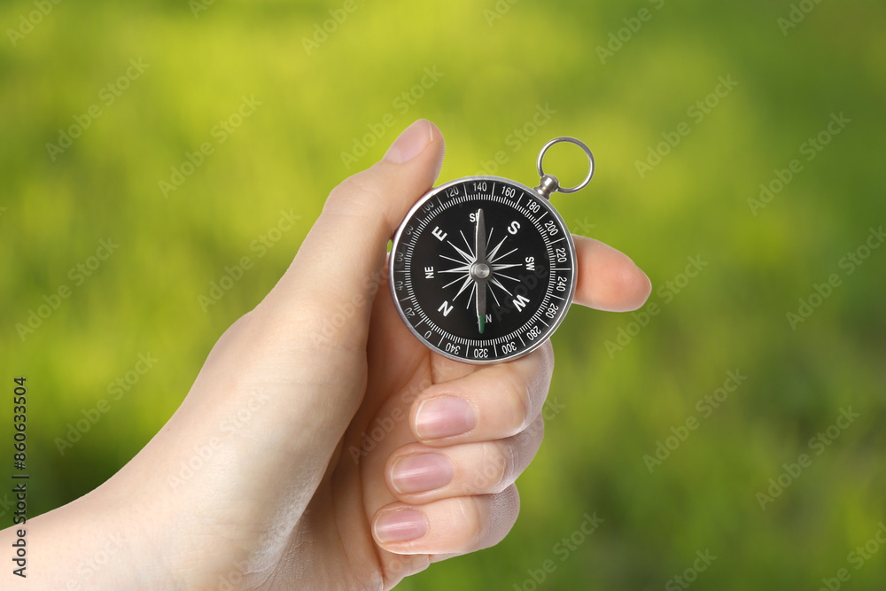 Woman holding compass in nature, closeup. Navigational instrument Woman holding compass in nature, closeup. Navigational instrument