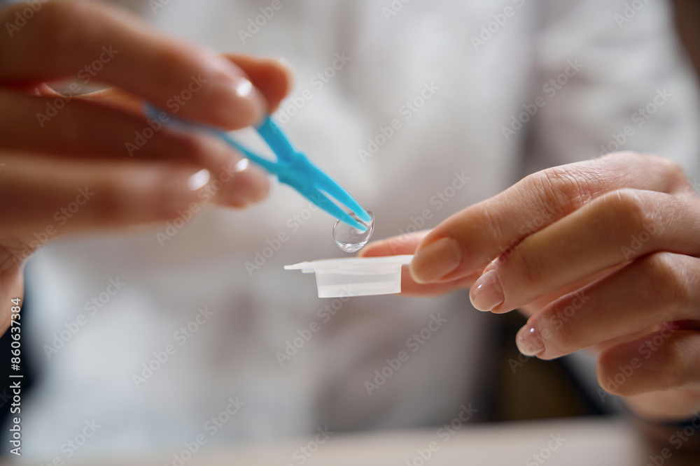 Lady puts a contact lens into a container Lady puts a contact lens into a container