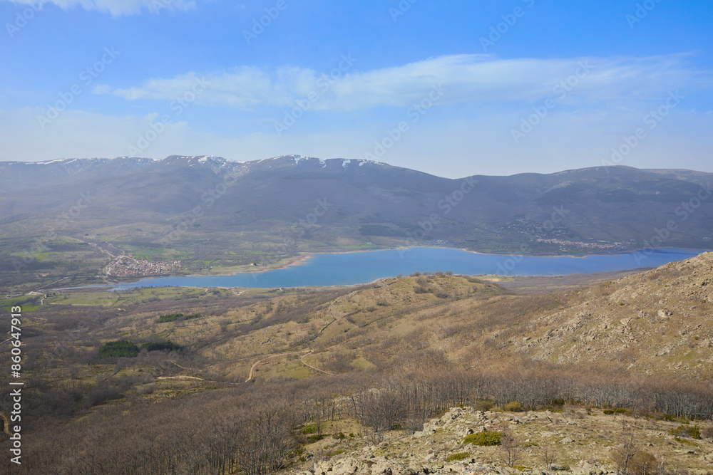 Fototapeta premium Reservoir in the Lozoya valley next to the town of Pinilla and the mountains of the Guadarrama National Park, in Madrid, Spain