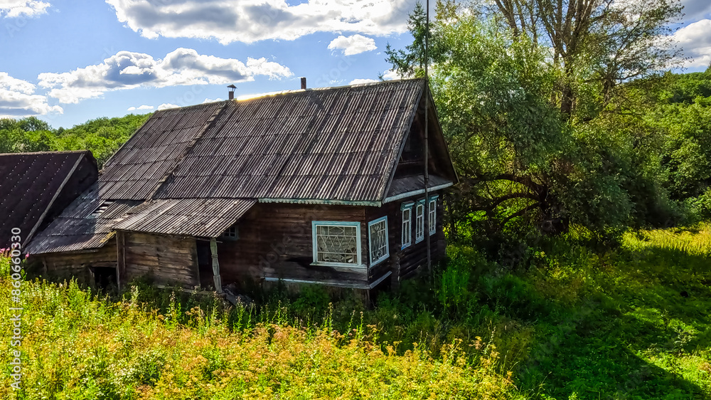 Old wooden house in the village on a sunny summer day Old wooden house in the village on a sunny summer day