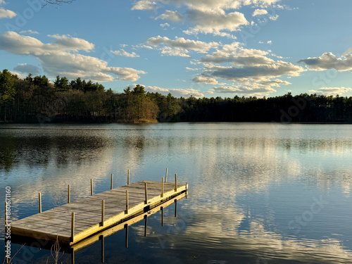 Pond life - A small boat dock reaches out into a quiet tree-lined pond in rural New England. photo