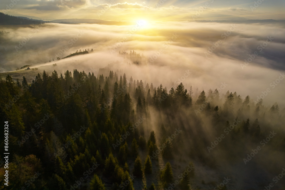 Fog spreads over the mountains at dawn. The sun rises on the horizon. Carpathians in the morning. Aerial drone view. Fog spreads over the mountains at dawn. The sun rises on the horizon. Carpathians in the morning. Aerial drone view.