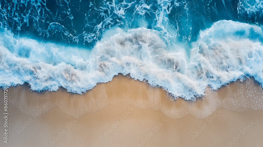 An aerial view of the ocean waves crashing onto golden sand, creating a symphony of blue and white hues. An aerial view of the ocean waves crashing onto golden sand, creating a symphony of blue and white hues.