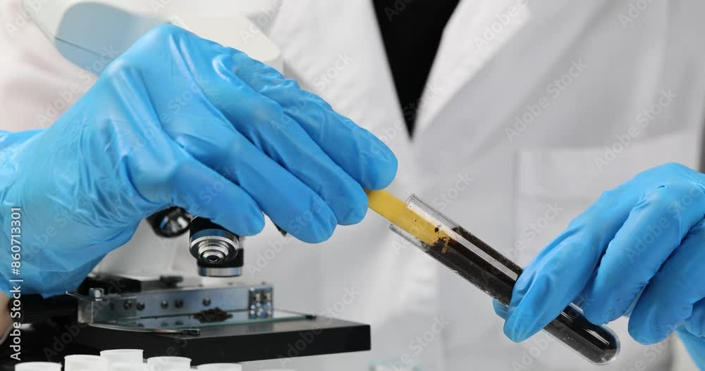 Chemist with gloves testing acidity level of soil in tube with medical device in laboratory. Tip of device changes color to purple slow motion Chemist with gloves testing acidity level of soil in tube with medical device in laboratory. Tip of device changes color to purple slow motion