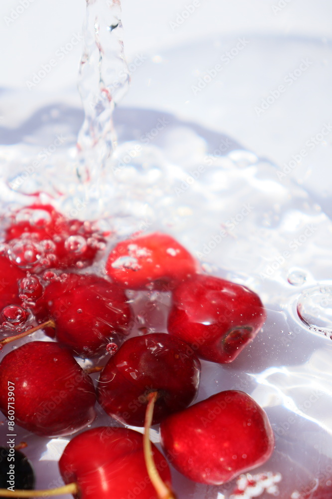 juicy bright red cherries in water on a white background juicy bright red cherries in water on a white background