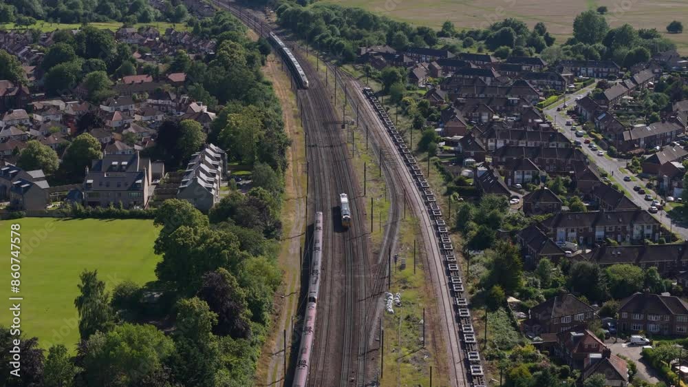 Aerial view of trains going past each other through town in England Aerial view of trains going past each other through town in England
