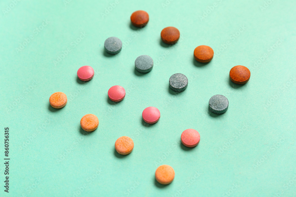 Square made of different pills on color background