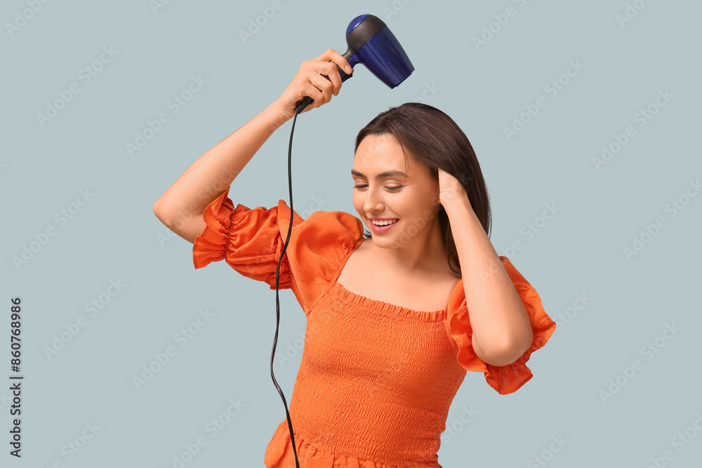 Beautiful young woman with hair dryer on light background Beautiful young woman with hair dryer on light background