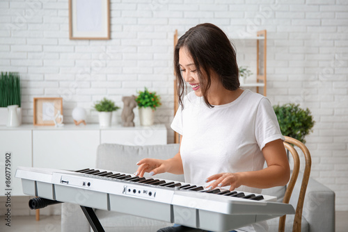 Young woman playing synthes...