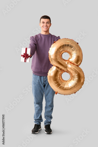 Handsome man holding balloo...