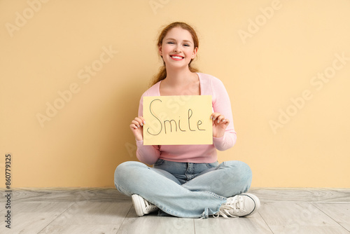 Young redhead woman holding...