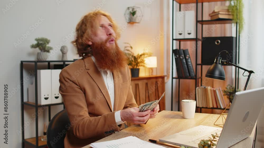 Excited Caucasian bearded businessman counting cash money dollar checking salary enjoy richness at modern workplace. Happy freelancer guy calculating currency profit financial savings in home office. Excited Caucasian bearded businessman counting cash money dollar checking salary enjoy richness at modern workplace. Happy freelancer guy calculating currency profit financial savings in home office.