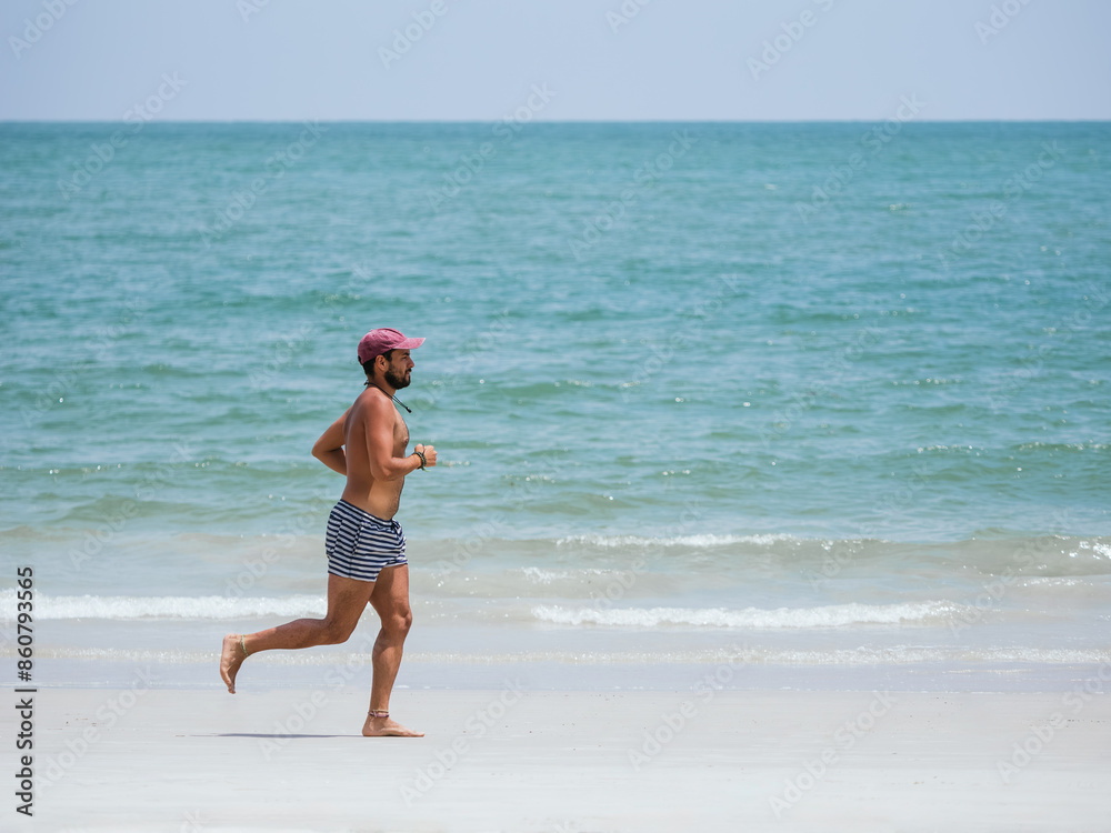 Fototapeta premium Man Running Barefoot on a Tropical Beach