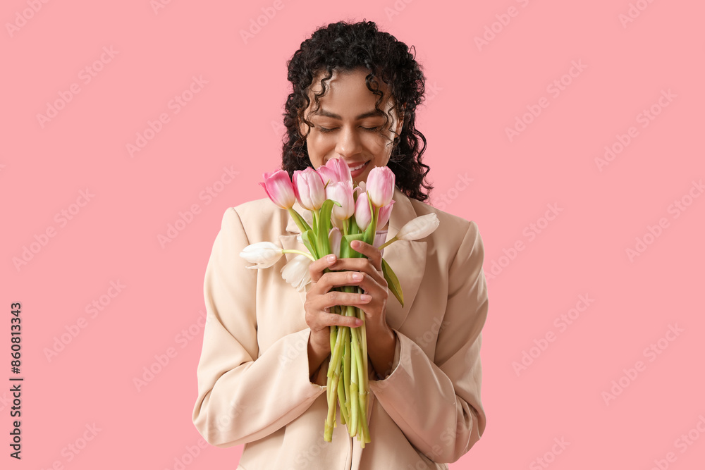 Beautiful young African-American woman with bouquet of tulips on pink background. International Women's Day Beautiful young African-American woman with bouquet of tulips on pink background. International Women's Day