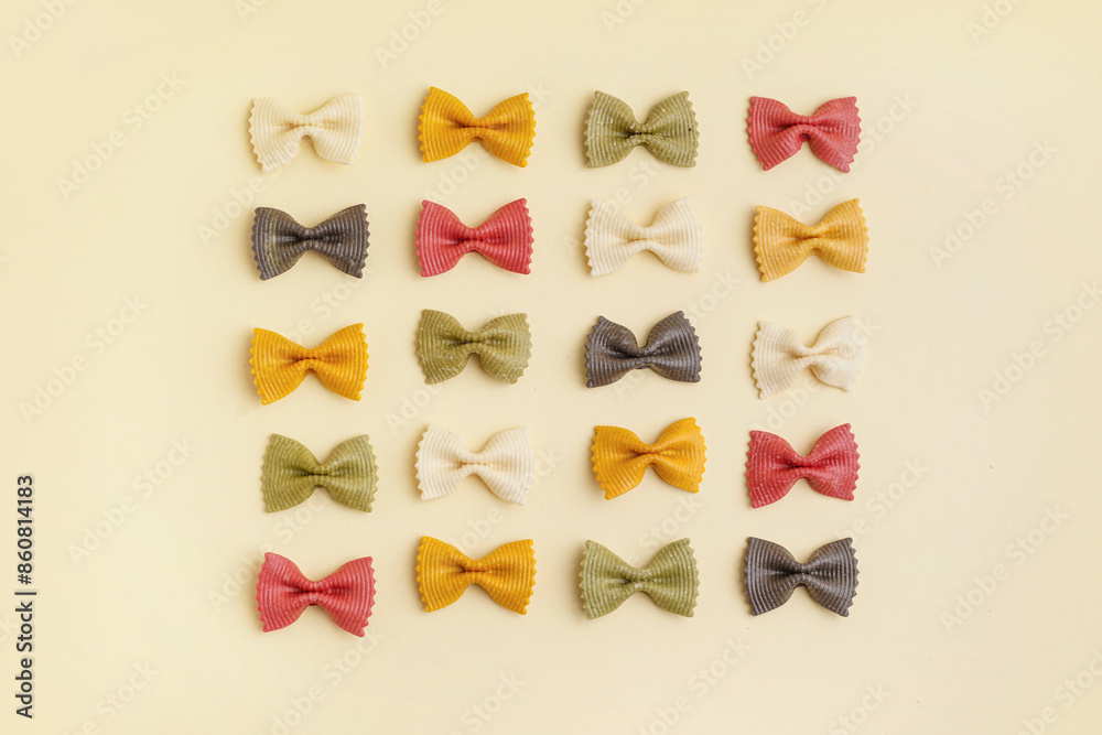 Composition with colorful uncooked farfalle pasta on beige background Composition with colorful uncooked farfalle pasta on beige background
