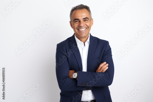 Portrait of happy mature businessman with crossed arms standing against white background