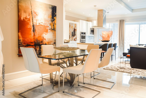 A contemporary dining room with a glass table, modern chairs, and abstract art.