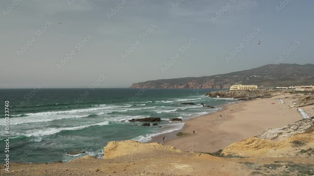 waves breaking at the rugged rocky coastline at cabo da roca, the western most point of european mainland, along the atlantic ocean of Portugal with steep cliffs and blue water. waves breaking at the rugged rocky coastline at cabo da roca, the western most point of european mainland, along the atlantic ocean of Portugal with steep cliffs and blue water.