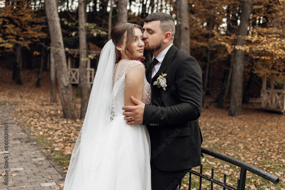Naklejka premium A bride and groom are hugging each other in a forest