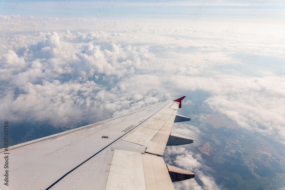 View from the airplane window at a beautiful cloudy sky and the airplane wing View from the airplane window at a beautiful cloudy sky and the airplane wing