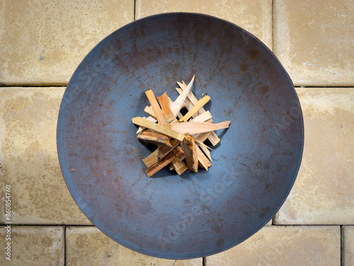 Round metal fire pit with wood kindling top view in outdoor patio