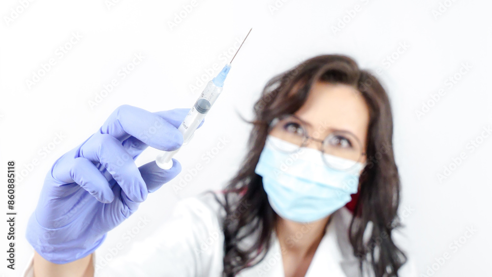 Nurse in blue face mask holding a syringe with a needle isolated on white background Nurse in blue face mask holding a syringe with a needle isolated on white background