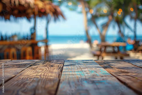 Wood table top product display with ocean water tiki bar with blue waves and palm leaves roof in the background. Tropical beach vacation product promotion for mobile sale 