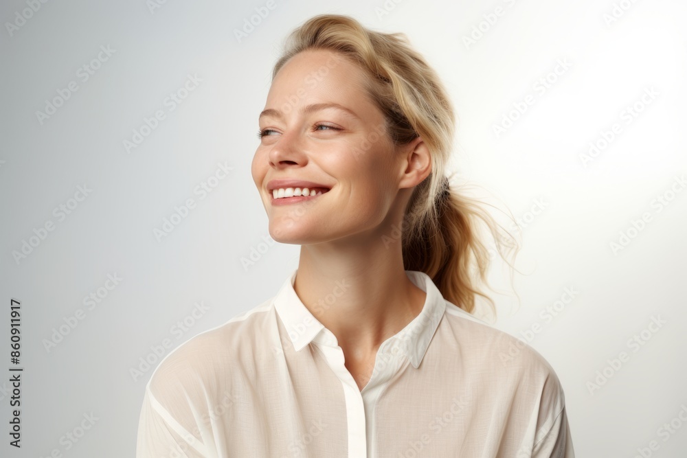 Portrait of a beautiful smiling young woman with blond hair on a gray background Portrait of a beautiful smiling young woman with blond hair on a gray background