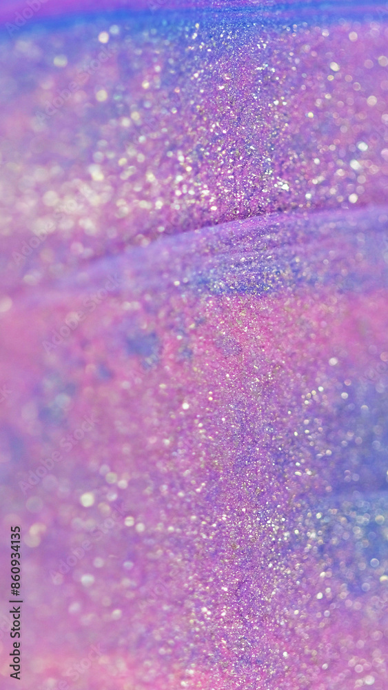 Glitter fluid texture. Liquid shimmer spill. Defocused pink purple color shiny particles wet glow ink gloss paint wave abstract art background with bokeh lights. Glitter fluid texture. Liquid shimmer spill. Defocused pink purple color shiny particles wet glow ink gloss paint wave abstract art background with bokeh lights.