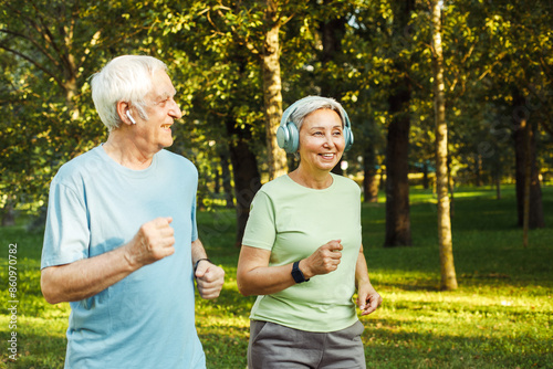 Smiling senior couple jogging in the park. Lifestyle, old people and sport concept.