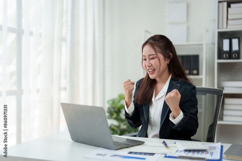 Surprised and happy businesswoman shows joyful expression after viewing news results, business approval results and financial approval results on laptop at office. Startup business growth concept. Surprised and happy businesswoman shows joyful expression after viewing news results, business approval results and financial approval results on laptop at office. Startup business growth concept.