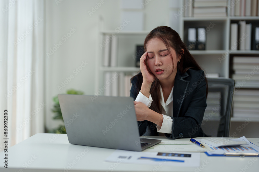 A businesswoman who is tired, stressed, and sore from working for a long time. After waiting for news Unsuccessful business approval results on laptop in office. Startup time concept, office syndrome A businesswoman who is tired, stressed, and sore from working for a long time. After waiting for news Unsuccessful business approval results on laptop in office. Startup time concept, office syndrome