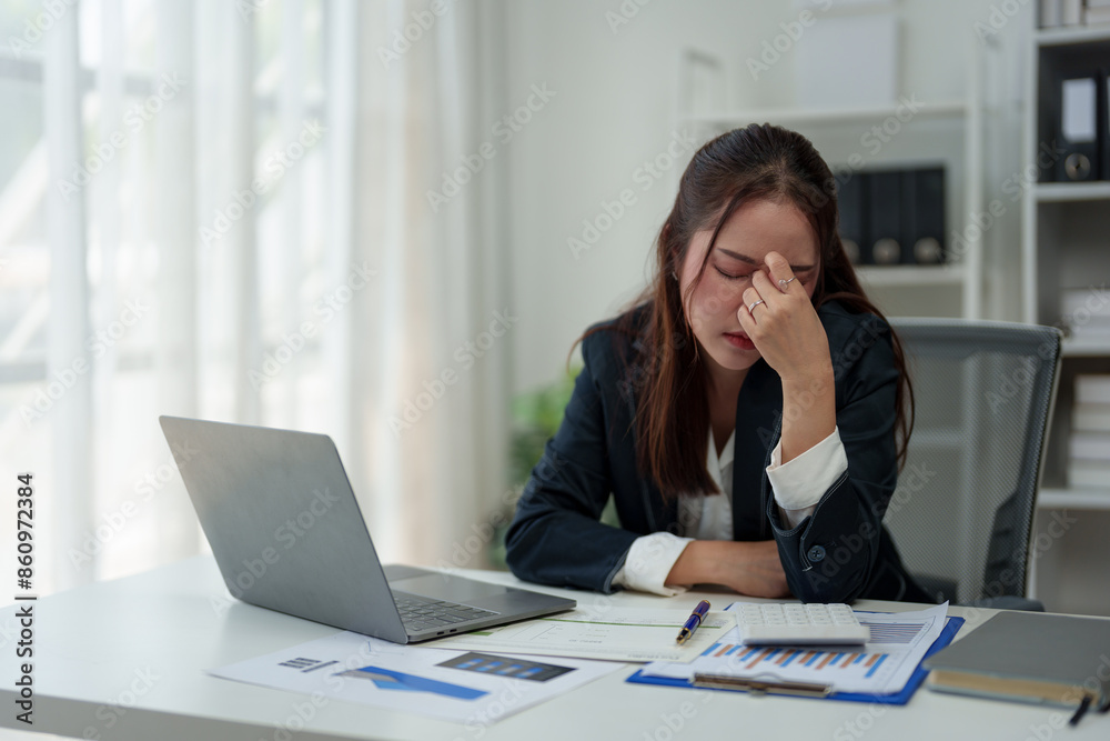 A businesswoman who is tired, stressed, and sore from working for a long time. After waiting for news Unsuccessful business approval results on laptop in office. Startup time concept, office syndrome A businesswoman who is tired, stressed, and sore from working for a long time. After waiting for news Unsuccessful business approval results on laptop in office. Startup time concept, office syndrome