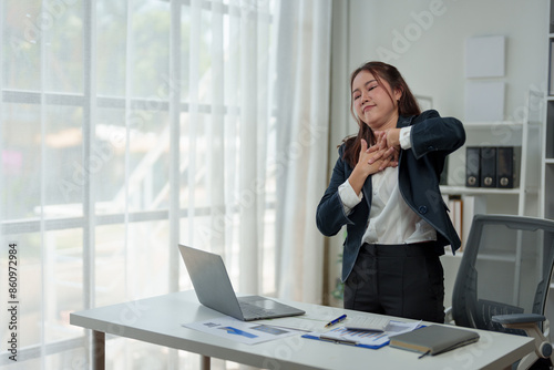 A businesswoman who is tired, stressed, and sore from working for a long time. After waiting for news Unsuccessful business approval results on laptop in office. Startup time concept, office syndrome