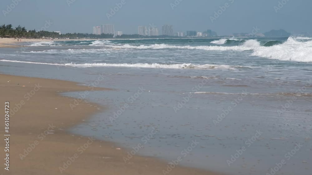 Tripod shot of a surf on An Bang beach on the background of Da Nang city on sunny morning. Hoi An, Vietnam. Tripod shot of a surf on An Bang beach on the background of Da Nang city on sunny morning. Hoi An, Vietnam.
