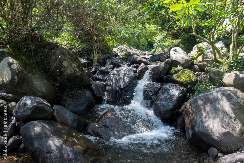 Calm river flowing between rocks and surrounded by trees on Mount Puntang, Bandung, West Java, Indonesia. Calm river flowing between rocks and surrounded by trees on Mount Puntang, Bandung, West Java, Indonesia.