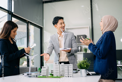 Group of diverse multiethnic businesspeople standing neare table looking at model of building from residential project. Green business company and Solar Energy Environment city photo