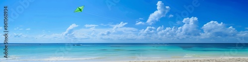 Serene beach scene with a green kite flying high in the sky, large clear area for adding text content