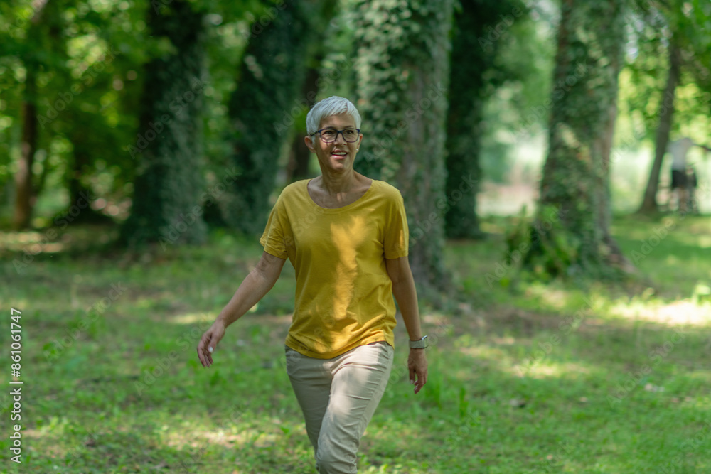 Senior woman enjoying a leisurely walk in the park for health and relaxation. Senior woman enjoying a leisurely walk in the park for health and relaxation.